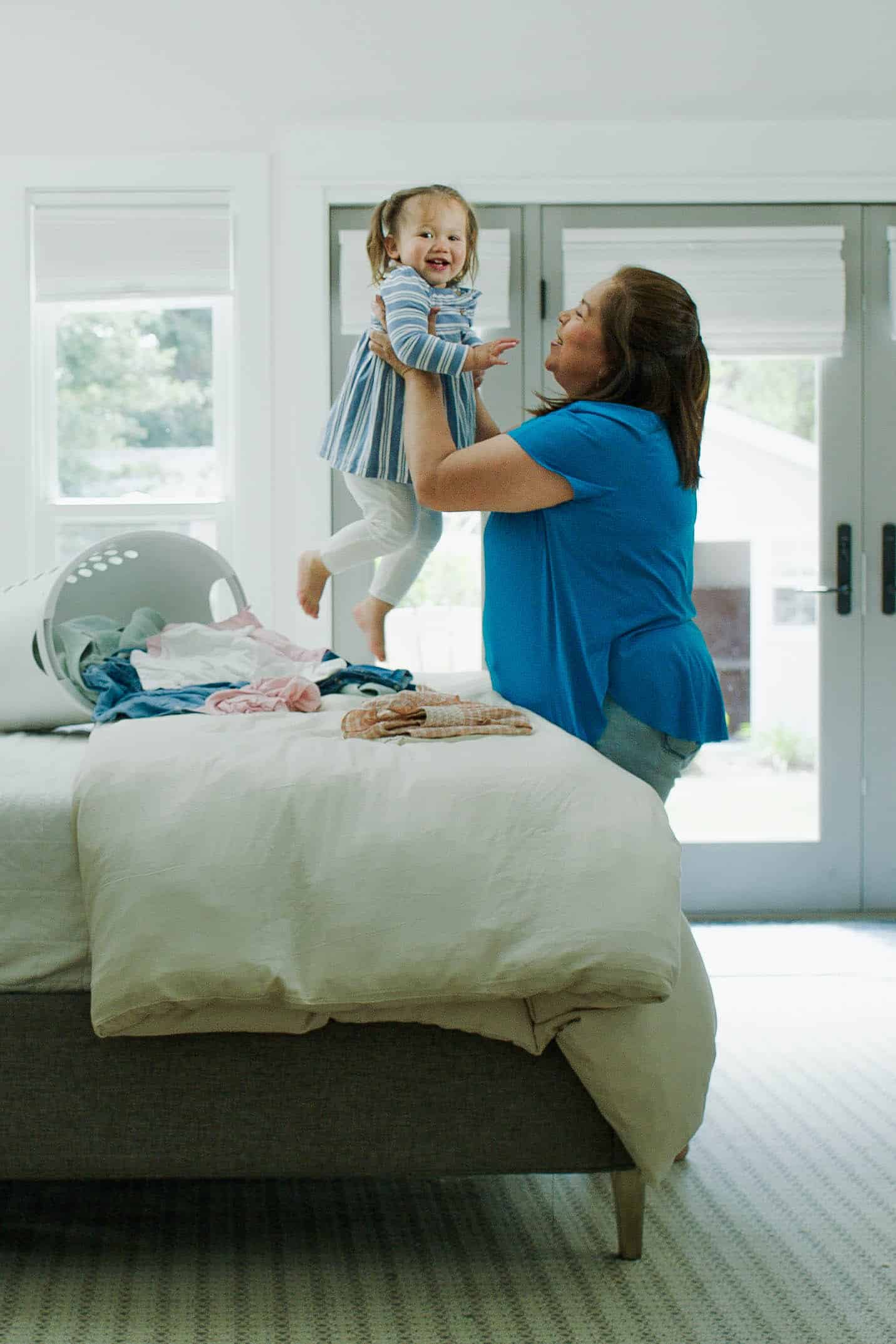 Career nanny lifting toddler in home environment